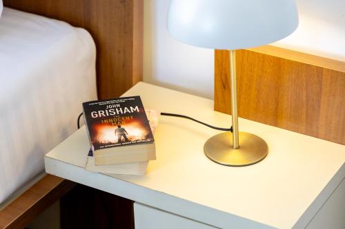 a book sitting on a table next to a lamp at Hotel Roberto Sinaia in Sinaia