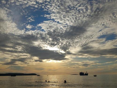 a group of people in the water under a cloudy sky at Homestay Lê Gia in Tuy Hoa