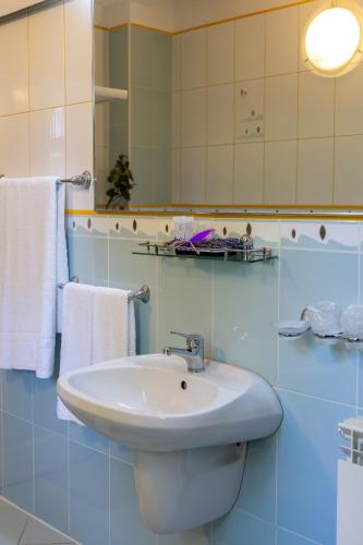 a bathroom with a white sink and a mirror at Hotel Roberto Sinaia in Sinaia