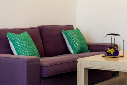 a purple couch with two green pillows and a table at Hotel Roberto Sinaia in Sinaia