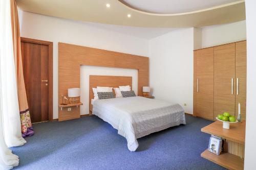a bedroom with a large white bed and wooden cabinets at Hotel Roberto Sinaia in Sinaia