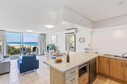 a kitchen and living room with a view of the ocean at One The Esplanade Apartments on Surfers Paradise in Gold Coast