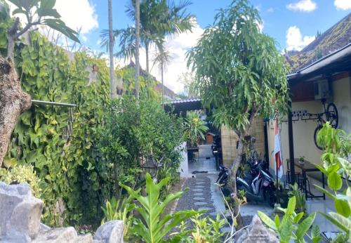 a house with a garden with trees and a fence at Coliving Bali SWEET HOME Kost Lengkap di Tabanan Kota in Tabanan