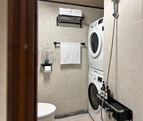 a bathroom with a washing machine and a toilet at Hayoungs House in Seoul