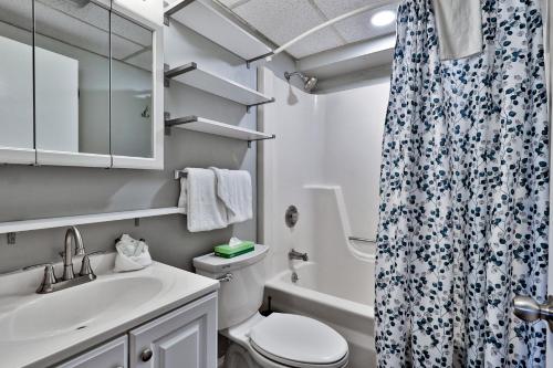a bathroom with a toilet sink and a shower curtain at The Snowshed Steps at Mt Green - Walk-to-Lifts Ski Condo with Pools, AC, Fireplace & Shuttle! in Killington