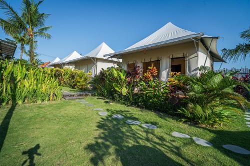 a house with a lawn in front of it at Paddy's Glamping Managed by Manara in Canggu