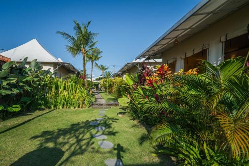 a garden next to a house with trees and plants at Paddy's Glamping Managed by Manara in Canggu