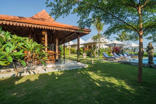 a resort with a pool and chairs in a yard at Paddy's Glamping Managed by Manara in Canggu