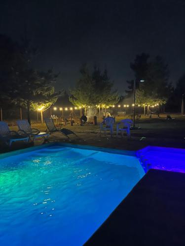 a swimming pool lit up at night with lights at Cabañitas Zelada in Algarrobo