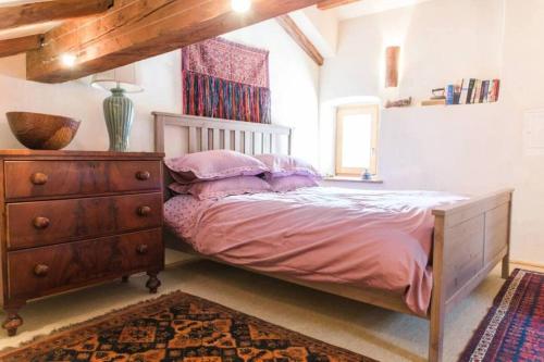 a bedroom with a bed with a dresser and a window at Tolmin Center Apartments Townhouse & Loft in Tolmin