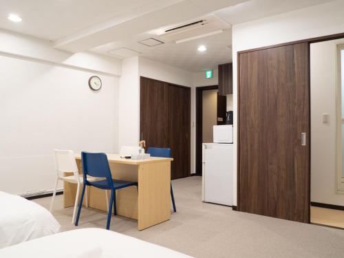 a room with a table and chairs and a kitchen at Shinjuku family apartment in Tokyo