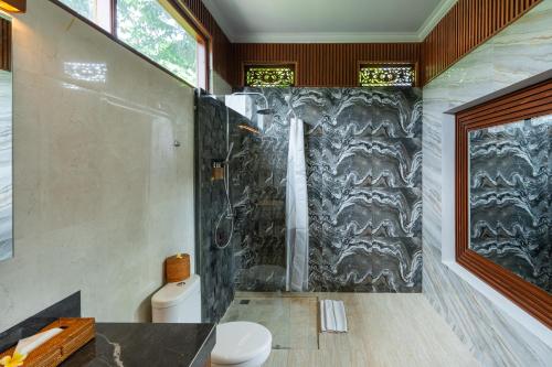 a bathroom with a shower and a toilet at The Bulih Ubud in Ubud