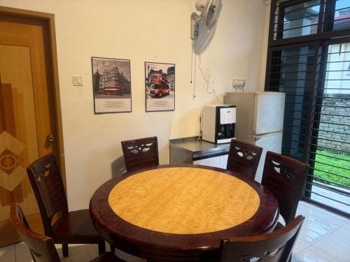 a kitchen with a table and chairs and a refrigerator at Taman Sri Utama Gurun 