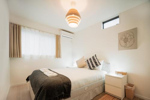 un dormitorio con una cama y una ventana en 静和 旅タイム千本南, en Osaka