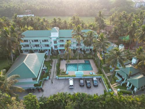 an aerial view of a resort with a pool and palm trees at D7 La Serene in Benaulim