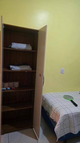 a bedroom with a book shelf next to a bed at Apro A com cozinha em Macapa in Macapá