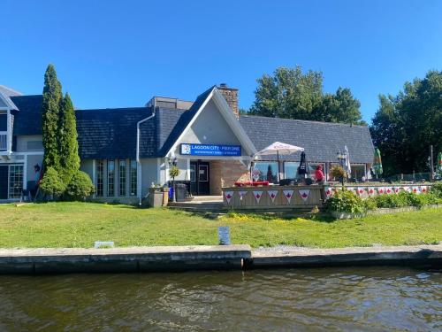 a building with a table on the side of a river at Beautiful Four Bedroom Lagoon City Waterfront Home in Brechin