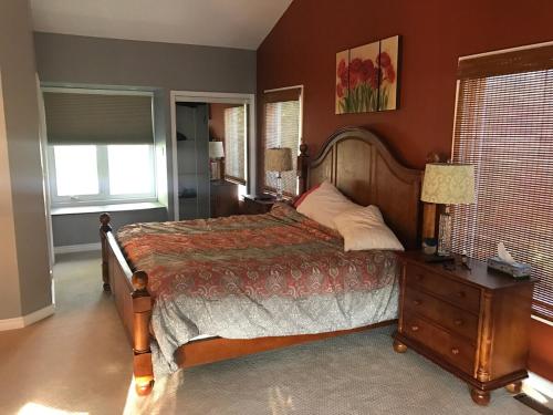 a bedroom with a bed and a table with a telephone at Beautiful Four Bedroom Lagoon City Waterfront Home in Brechin