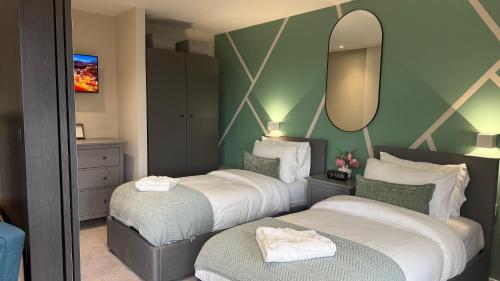 two beds in a hotel room with a mirror at Luxury Apartment in City Centre - Free Parking in Manchester