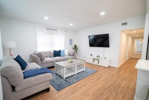 a living room with two couches and a tv at Beautiful Spacious Stylish near Busch Gardens in Tampa