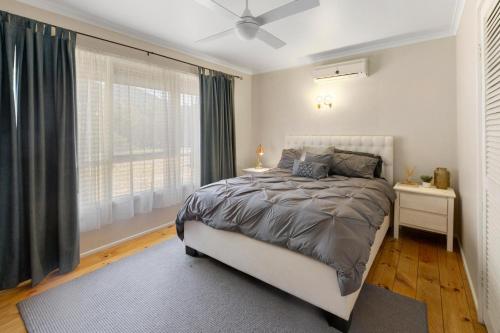 a bedroom with a bed and a large window at Sunset Cove in Piries