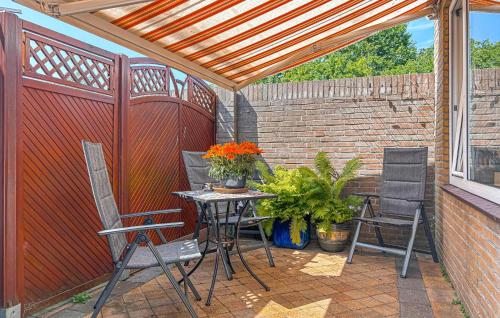 a patio with a table and chairs and a fence at 2 Bedroom Beach Front Home In Egmond Aan Zee in Egmond aan Zee