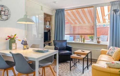 a living room with a table and chairs and a couch at 2 Bedroom Beach Front Home In Egmond Aan Zee in Egmond aan Zee