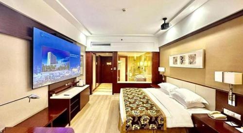 a bedroom with a large bed and a large tv at Xiangsheng Century Hotel Zhuji in Shaoxing