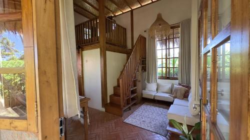 a living room with a couch and a staircase at Santai House in Tetebatu