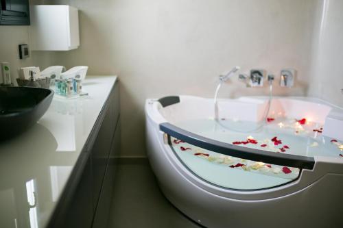 un bagno con lavandino con fiori rossi di Zafira Residence a Karterados