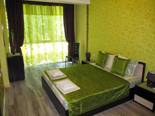 une chambre verte avec un lit et une fenêtre dans l'établissement Apartments Vasil Levski, à Plovdiv