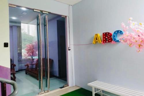 a room with a glass door with a sign on the wall at ABC Hostel in Seri Kembangan