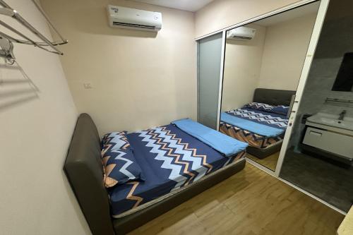 a small room with two beds and a mirror at ABC Hostel in Seri Kembangan