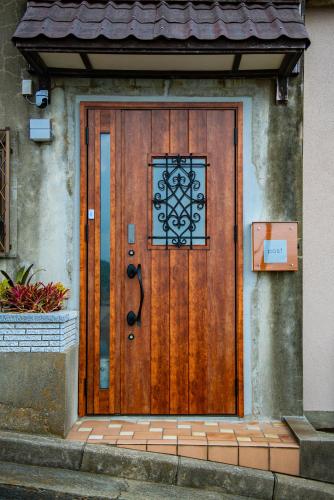 a wooden door of a house with a sign on it at Ｊ Studio Oarai in Hokota