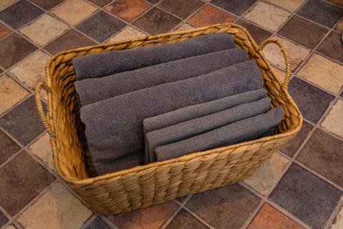 a basket filled with black towels on a tile floor at Ｊ Studio Oarai in Hokota