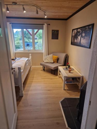 a living room with a bed and a couch at Villa Svale, privat og fredelig in Kristiansand