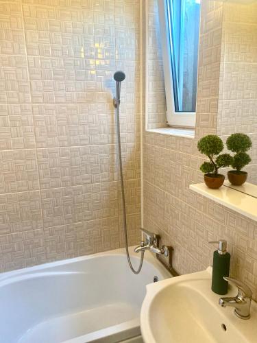 a bathroom with a white tub and a sink at Garsoniera ultracentrală1 in Piteşti