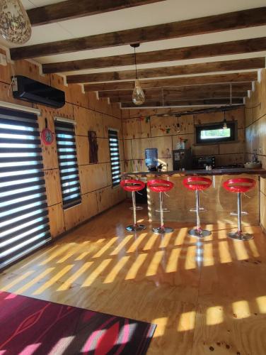 a room with red stools in the middle of a kitchen at Cabaña privada con acceso a playa in Castro