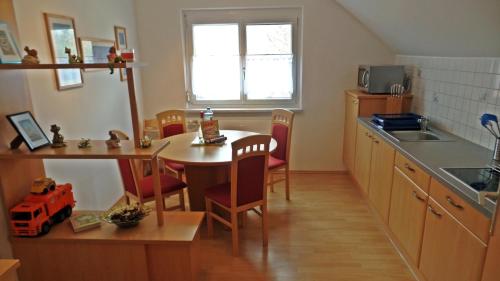 a kitchen with a table and chairs and a kitchen with a sink at Haus Floresa in Lutzmannsburg