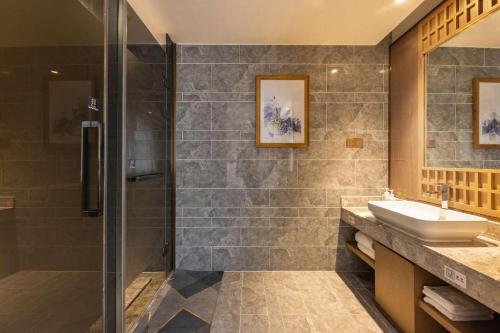 a bathroom with a sink and a shower at East Queen Hotel (Xi'an Beimen Metro Station) in Xi'an