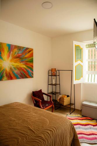 a bedroom with a bed and a painting on the wall at Entre balcones in Jericó
