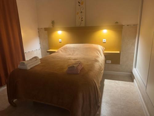 a bedroom with a bed with two slippers on it at Alquiler por Dia Alca!!!! in Viedma