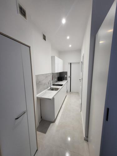 a white kitchen with a sink and a counter at Apartament Centrum in Gdynia