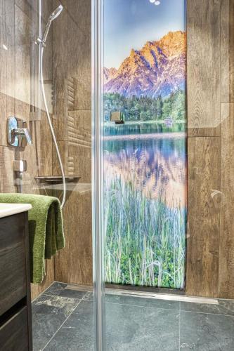 a bathroom with a shower with a view of a lake at Gästehaus Alpina in Krün
