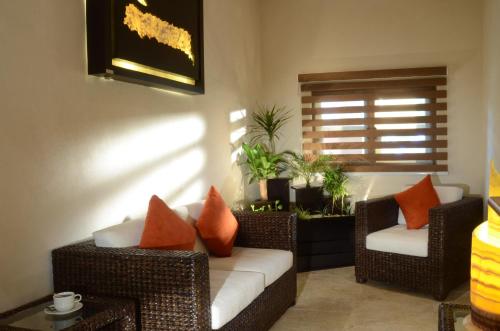a living room with wicker chairs and a couch at Hacienda Jurica by Brisas in Querétaro