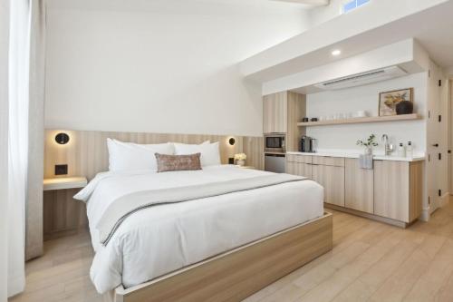 a bedroom with a large bed and a kitchen at Casa Riviera - Boutique Suites in Downtown Santa Barbara in Santa Barbara
