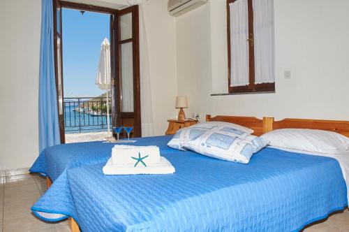 a bedroom with a blue bed with a towel on it at Kamares Studios in Symi