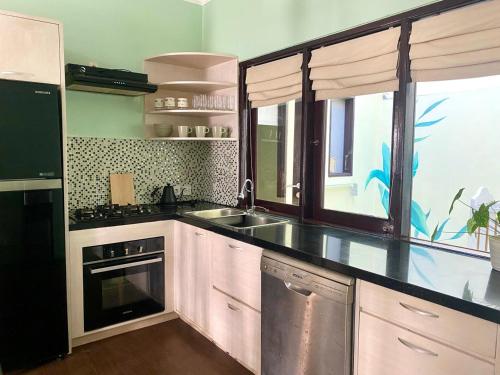 a kitchen with a sink and a stove at Palm Light Nusa Dua in Nusa Dua