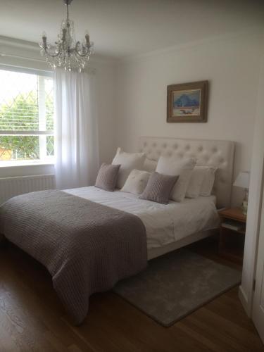 
a bedroom with a white bedspread and white pillows at B&B The Little Garth in Bexhill
