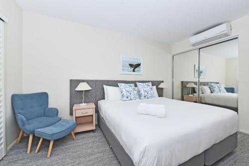 a bedroom with a bed and a blue chair at Pacific Blue Unit 175 Dual Swim Up B in Salamander Bay